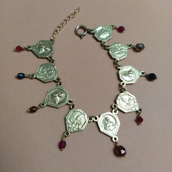 Bracelet composé d'anciens coeurs de chapelets et de perles de verre dans un camaïeu de rouge.