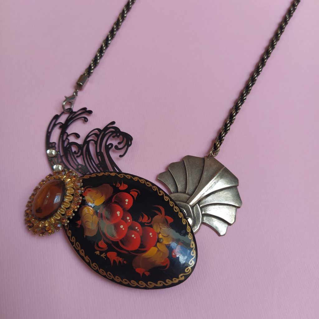 Collier composé d'une chaîne vintage  d'une ancienne boucle d'oreille  d'une broche vintage russe  d'une autre broche ancienne strassée et d'un élément de collier filigrané contemporain.