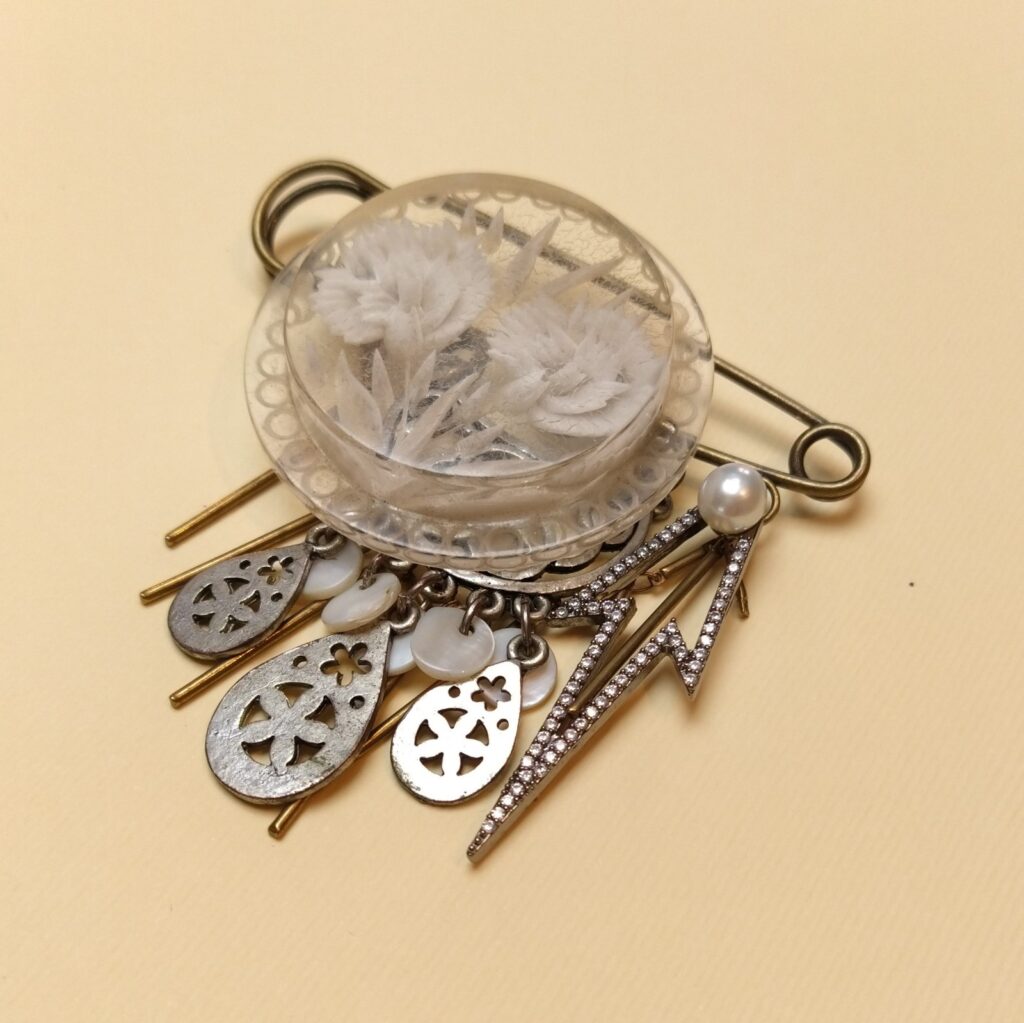 Broche de 8 cm constituée de petits trésors vintage et chaîne bâton en laiton bronze.