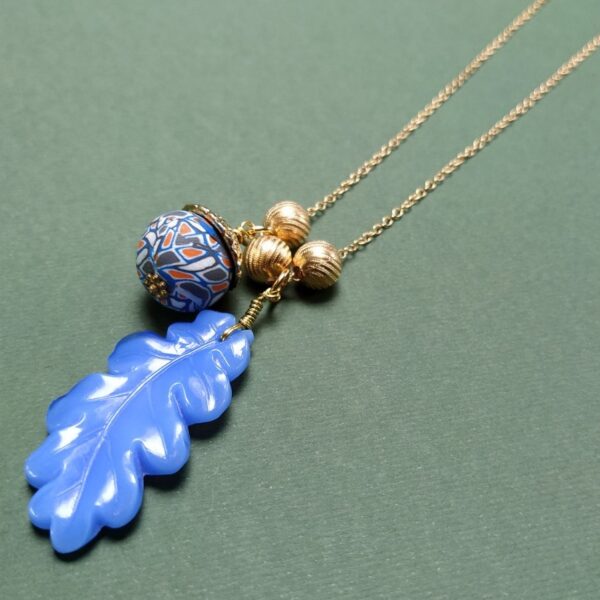 Collier composé d'un pendentif en forme de feuille de chêne en verre issu de la période Art Déco accompagné de diverses perles vintage.